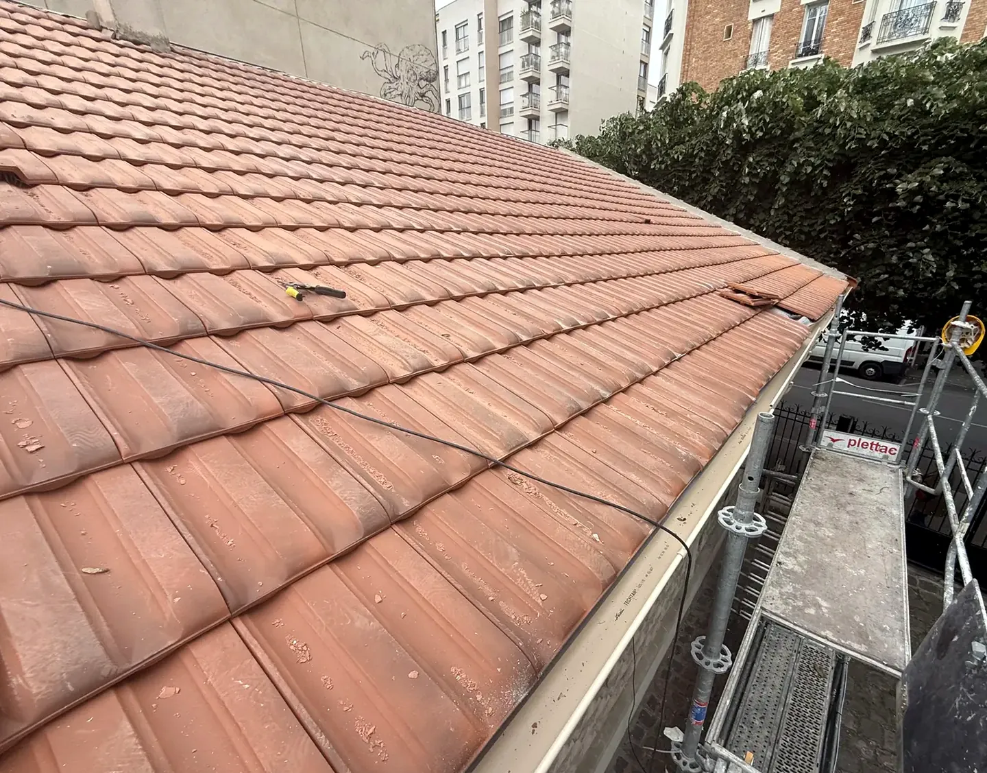 Couverture en tuiles mécaniques et chéneau en zinc en rive de toit, vue depuis l’échafaudage sur un chantier de Will Couvreur
