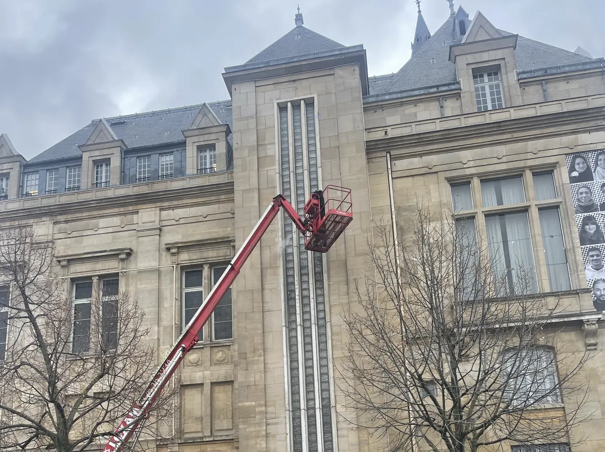 Nacelle élévatrice déployée le long de la façade en pierre de taille d’un hôtel de ville, un couvreur de l’entreprise Will dans le panier, au niveau du premier étage