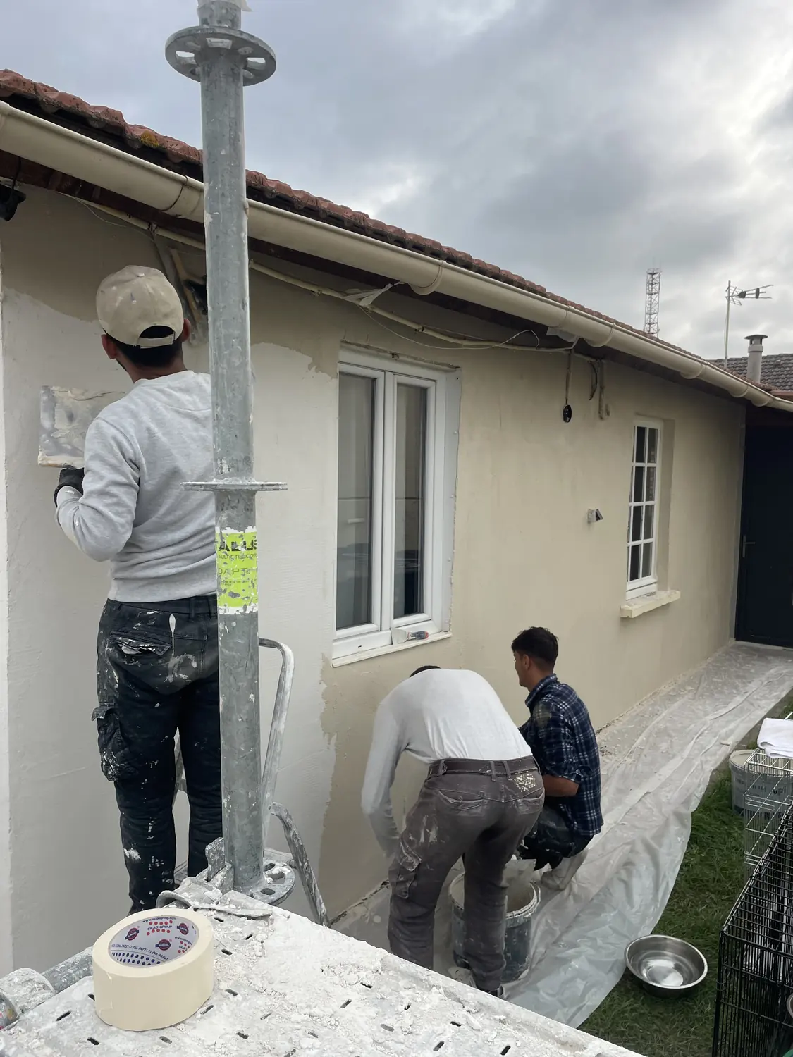 Application de la peinture de façade par l’équipe, en fin de ravalement